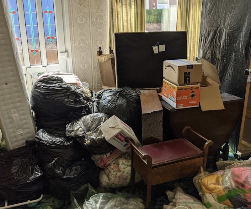 A house clearance Birmingham. A living room piled high with bulky waste.